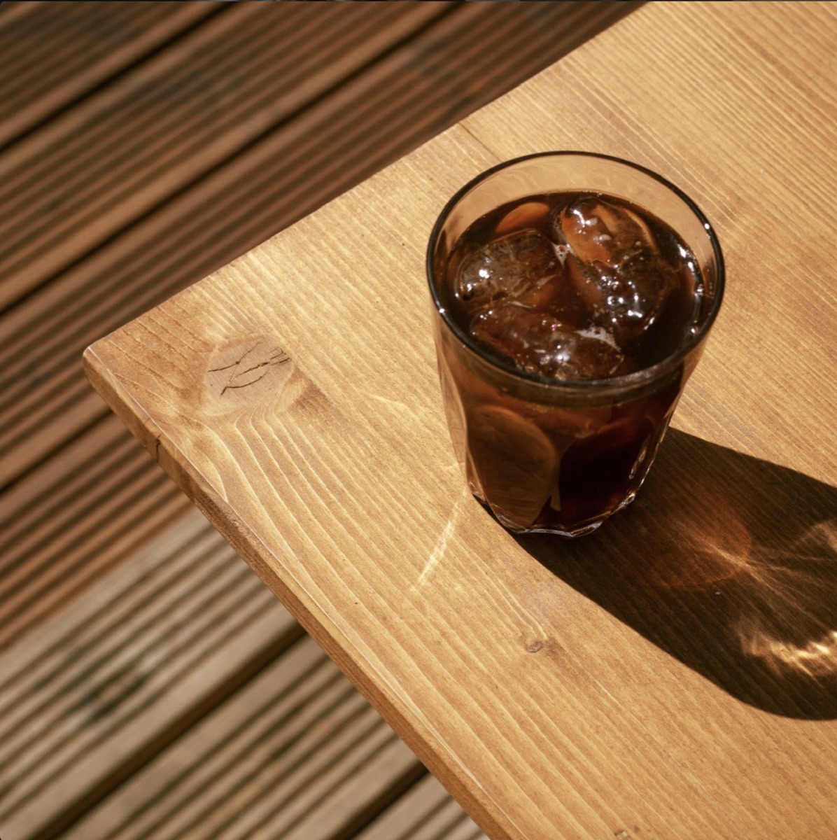 Iced coffee on a sunlit wooden table