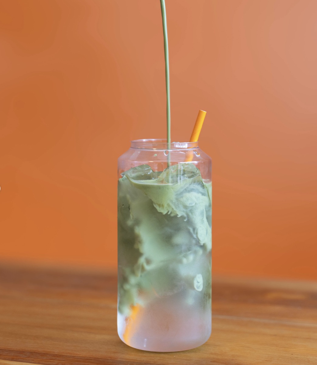 Iced matcha with an orange straw